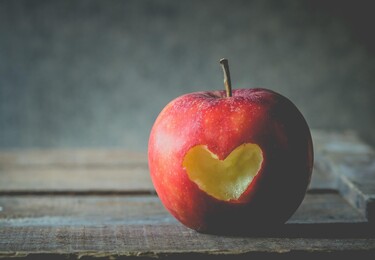 A picture of an apple with a heart bitten out